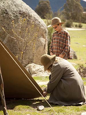 Two people pitching a tent